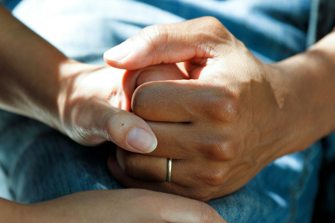 Geste de soutien auprès d’une personne en tenue de soins. Photographie d’illustration, sans diagnostic attribué aux personnes représentées.