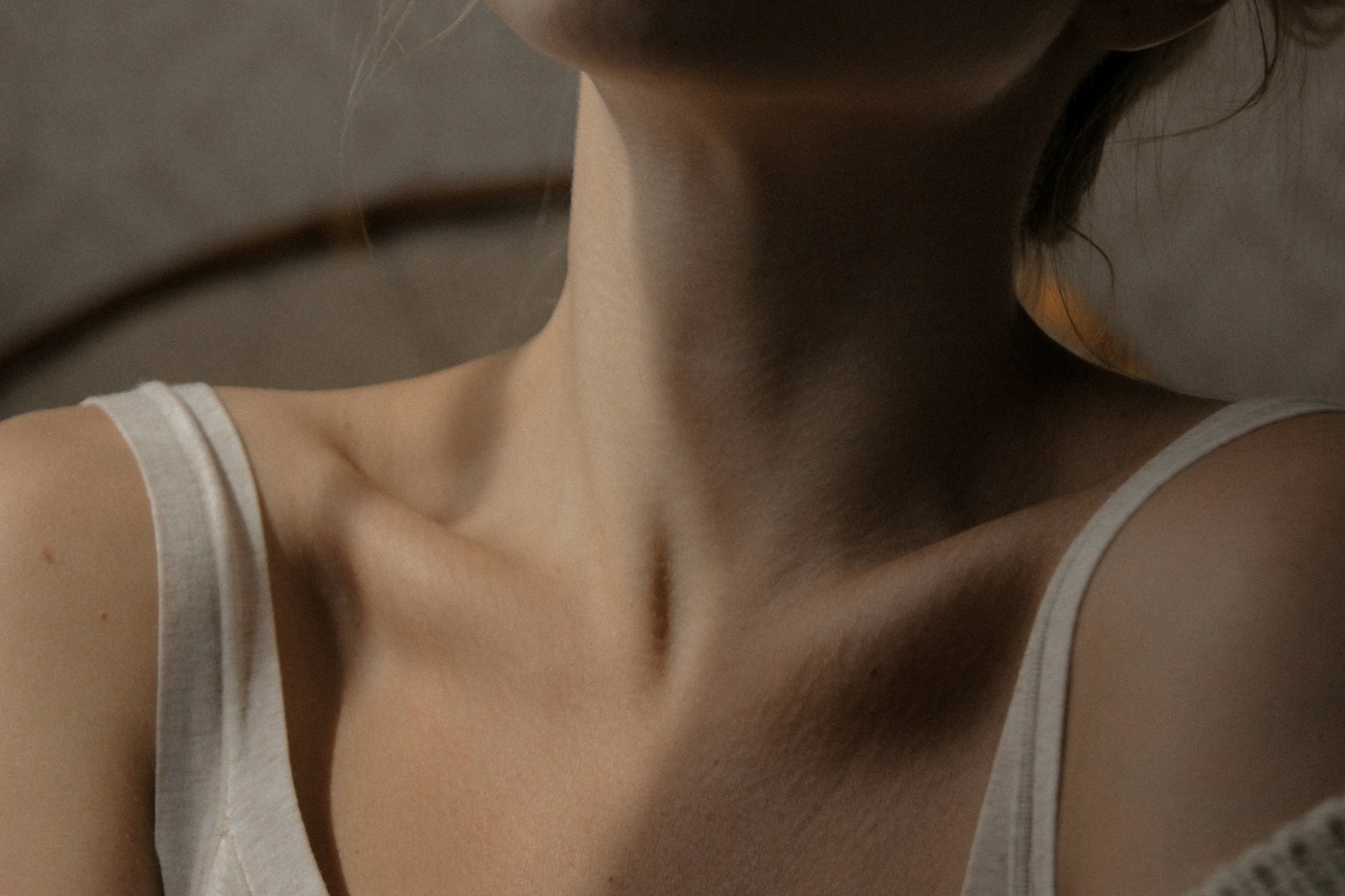 Cou et haut du buste d’une personne. Photographie d’illustration de la région thyroïdienne, sans maladie ni signe clinique attribué.