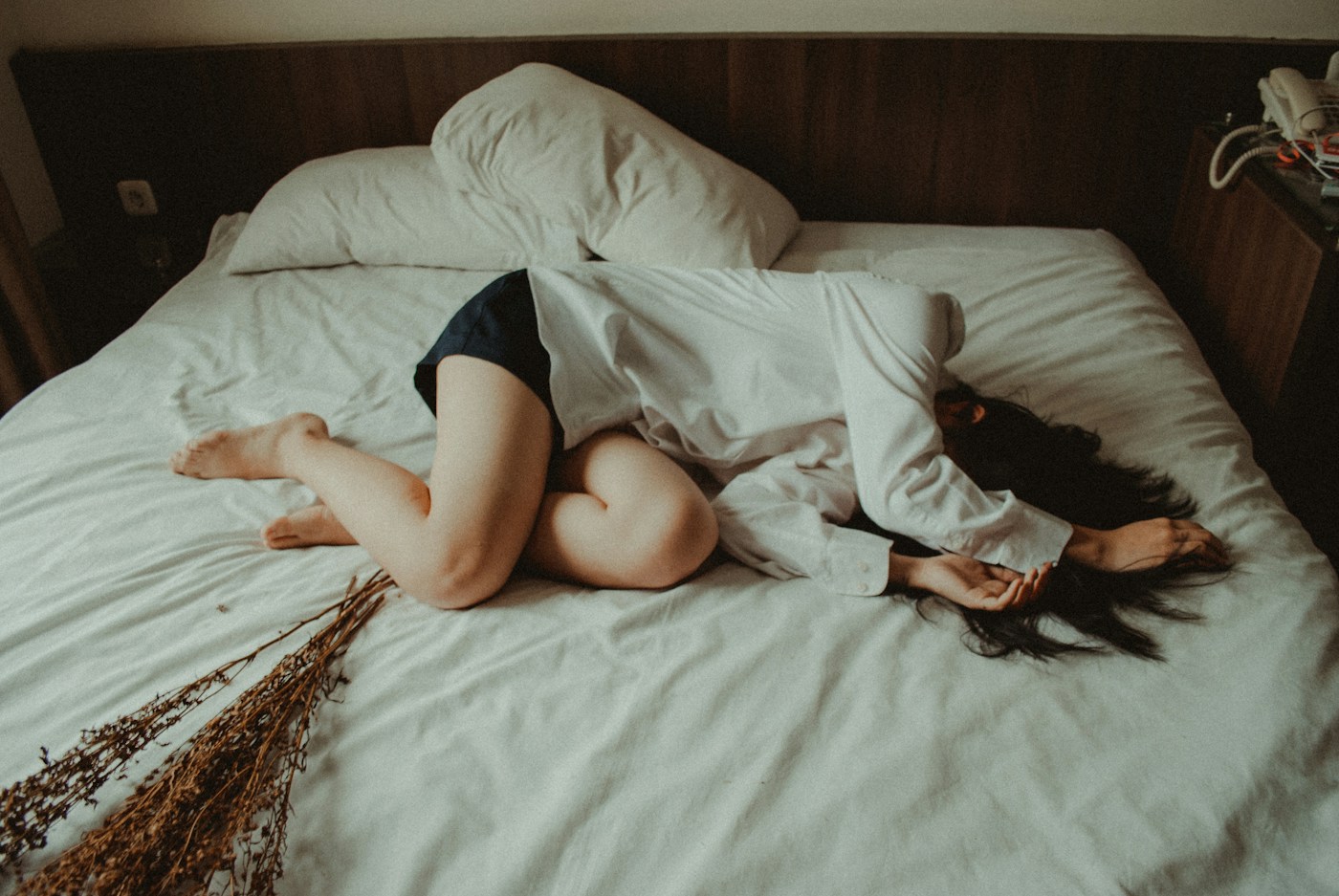 Personne allongée sur un lit. Photographie d’illustration de la douleur, sans maladie intestinale attribuée.